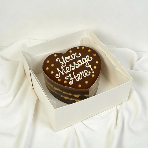 Heart-shaped chocolate brownie cake with 'Your Message Here' text (you can choose your own text. The cake is in a white box 